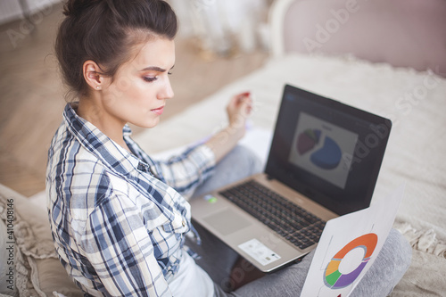 Woman working on laptop. Remote worker indoors. photo