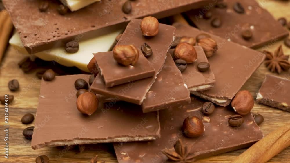 Pieces of Delicious Milk Chocolate with Hazelnut Filling and Coffee, Rotation, Close-up. Background of Chocolate Bars. Chocolate for Breakfast. Pieces of Delicious Milk Chocolate with Hazelnut Filling and Coffee, Rotation, Close-up. Background of Chocolate Bars. Chocolate for Breakfast.