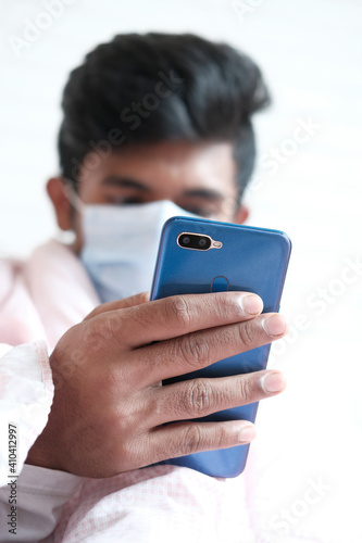 sick man in surgical face mask using smart phone, selective focus 