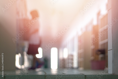 Education background concept. Hallway in front of classroom with blur young elementary student packing stuff in locker to leave school at the end of semester.