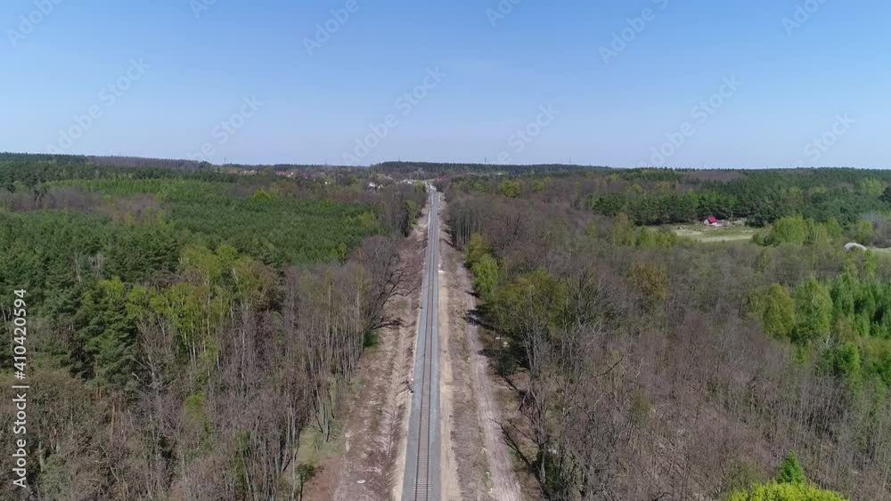 Modernized railway tracks in the forest. A drone shot taken on a beautiful sunny day with a blue sky. Modernized railway tracks in the forest. A drone shot taken on a beautiful sunny day with a blue sky.