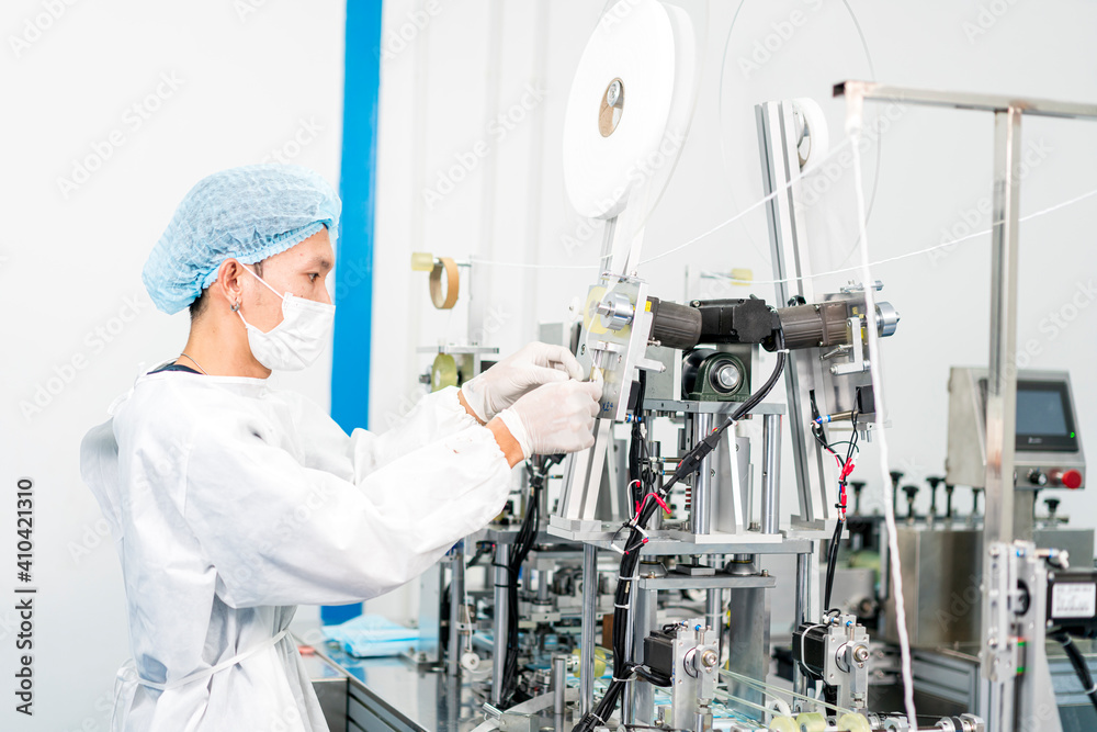 Staff and workers at the mask factory are monitoring the operation of the machines. A mask is being produced on the road. Staff and workers at the mask factory are monitoring the operation of the machines. A mask is being produced on the road.