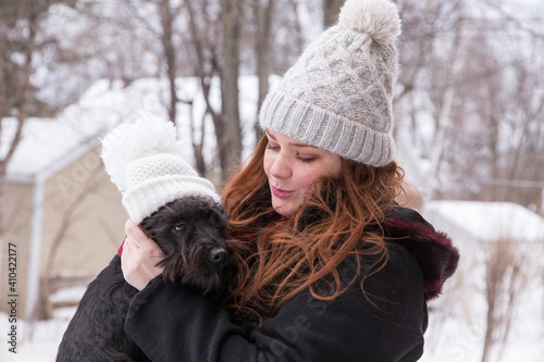 Quadro em tela Medium shot of cute red-haired young woman in winter clothes holding and fixing