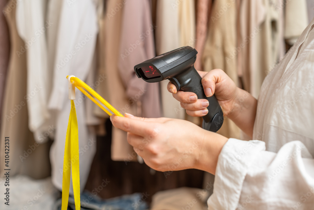 A warehouse woman scanning id cards of employee using barcode scanner in female clothing store