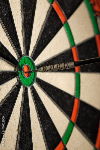 Dart in the center of a target, bullseye on dartboard