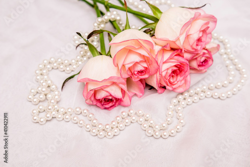 The branch of pink rose on white fabric background 