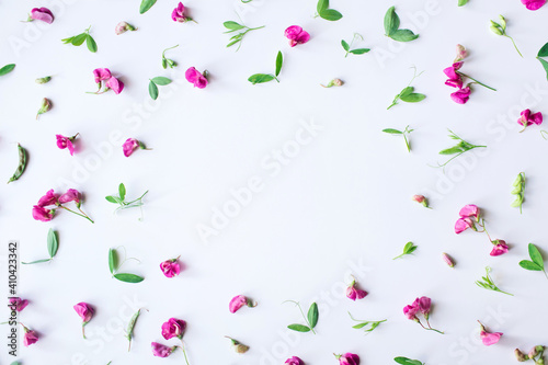 Flowers composition. Frame made of pink flowers and leaves on white background. Spring, easter, summer concept. Flat lay, top view, copy space.