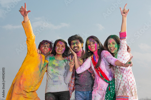 YOUNG MEN AND WOMEN POSING TOGETHER WHILE CELEBRATING HOLI 