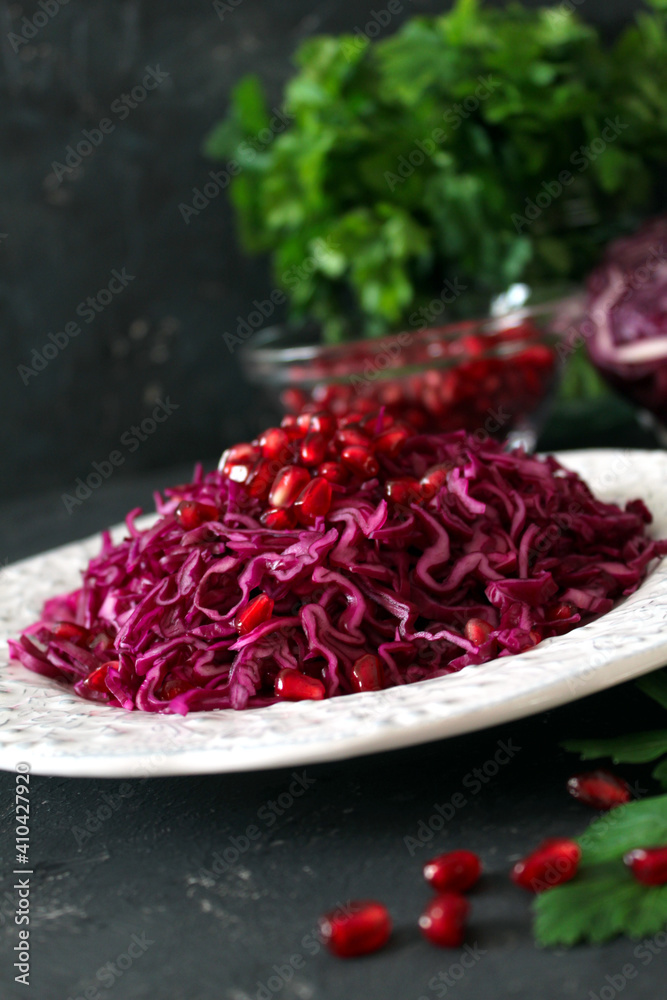 Red cabbage salad with pomegranate. Diet food. Top view with copy space.