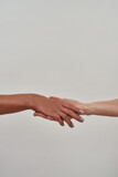 Close up of hand holding another hand. Gesture of salvation, guardianship isolated over light background