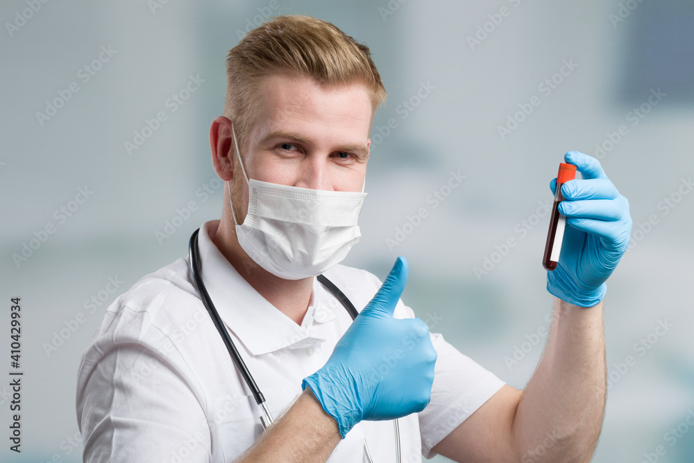 doctor with medical face mask and blood probe shows thumbs up doctor with medical face mask and blood probe shows thumbs up