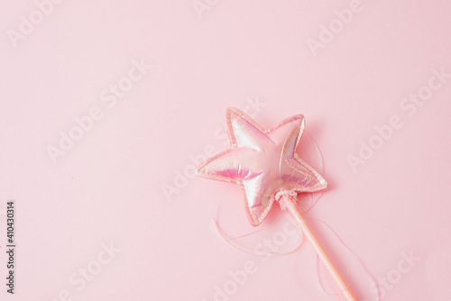 Pink magic wand. Star shape fairytale accessory. Valentines day background with copy space.
