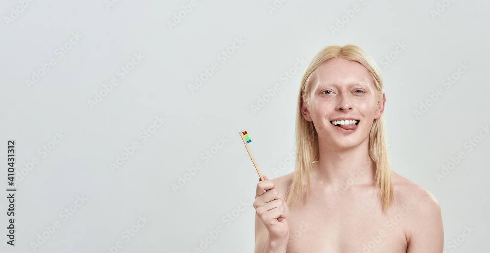 Smiling young man holding toothbrush in hand Smiling young man holding toothbrush in hand