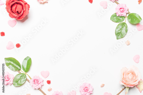 Frame made of rose flowers on white background. Top view with copy space.
