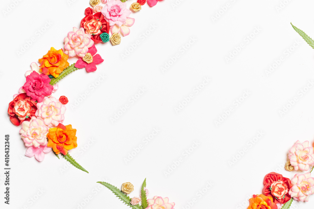 Frame made of rose flowers on white background. Top view with copy space.