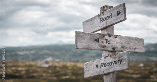road to recovery text engraved on wooden signpost outdoors in nature. Panorama format.