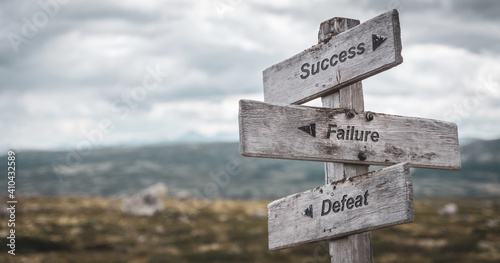 success failure defeat text engraved on wooden signpost outdoors in nature. Panorama format.