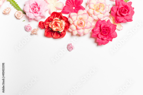 Frame made of rose flowers on white background. Top view with copy space.