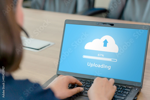 Woman doing cloud uploading on laptop in office. photo