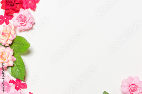 Fototapeta Naklejka Na Ścianę i Meble -  Frame made of rose flowers on white background. Top view with copy space.