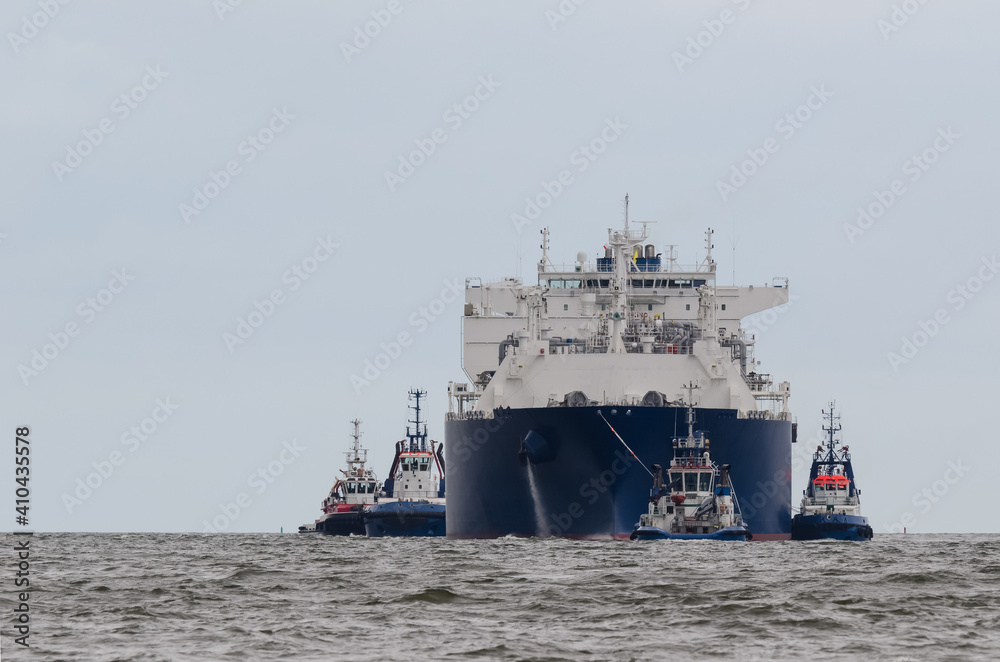LNG TANKER - The ship sails assisted by tugs 