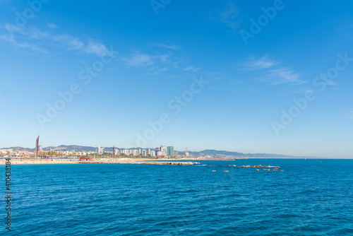 BARCELONA, SPAIN, FEBRUARY 3, 2021: Barcelona coast a sunny winter day. During the covid-19 pandemic. View from inside the water. In the background we can see the new modernist buildings on the coast. © Xavi Lapuente