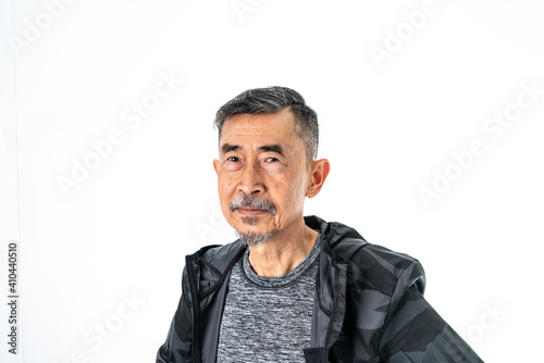 A smile of happy cool Asian elder man faces in a gray t-shirt And a black coat. Close-up Shoot On a white background in the studio. Positive active old senior, and healthy concept