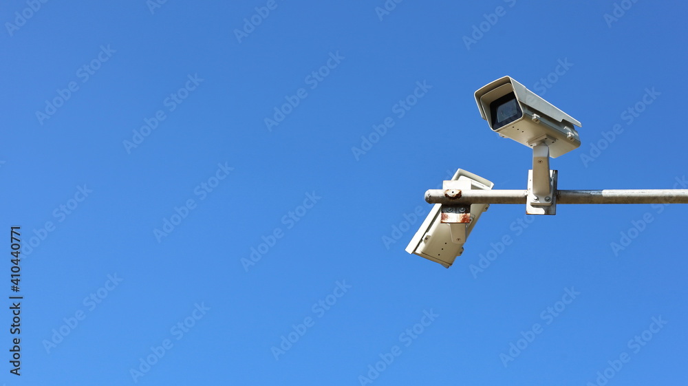 CCTV or security camera on a bright blue sky background with copy space. Focus closely and choose the subject. CCTV or security camera on a bright blue sky background with copy space. Focus closely and choose the subject.