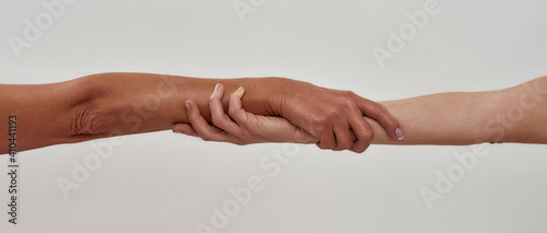 Close up shot of two female hands rescuing or holding each other strongly isolated over light background