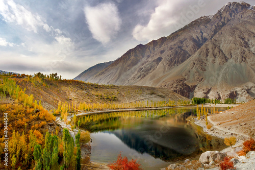 beautiful lake in the mountains with autumn trees and colorful bushes around the lake , phandar lake in autumn at ghizar valley gilgit baltistan , Pakistan  photo