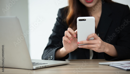 Businessman hands using smartphone and Computer notebook at the office desk. Blank screen mobile phone for graphic display montage