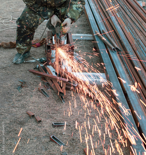 A worker cuts metal at a construction site. Technology