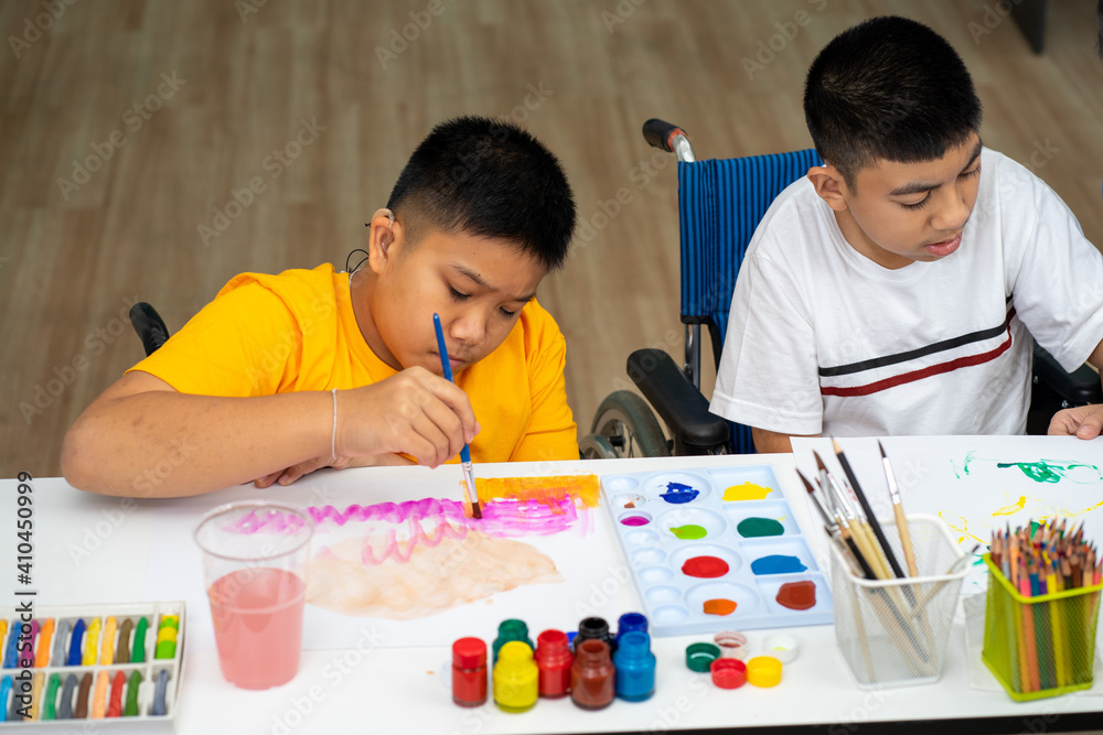 Asian disability boy learning color Painting in classroom with Autism girl in special school with female teacher.