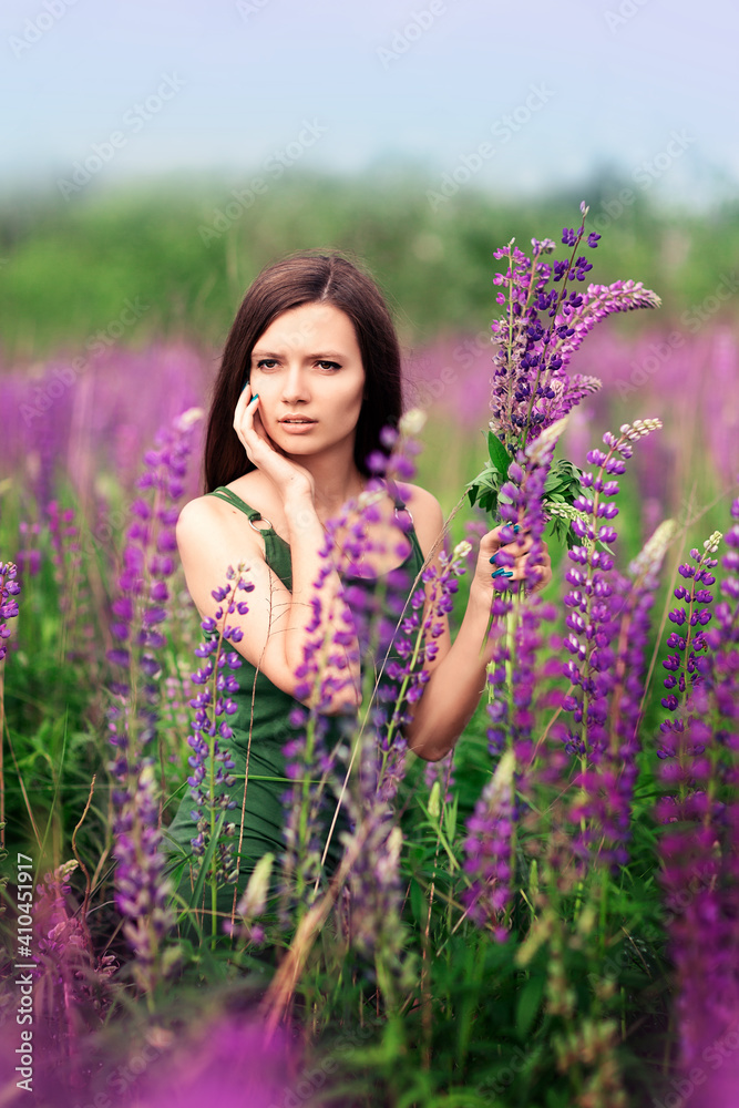 girl in a green dress on a lupine field. summer day girl in a green dress on a lupine field. summer day