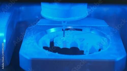 Dental milling cnc machine carving out shape of human teeth close-up.