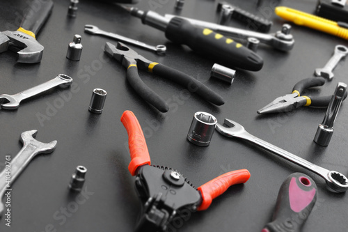 Many different tools for repair work on a black background.