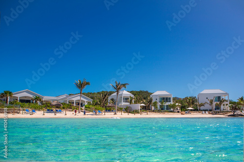 Beautiful caribbean villas on a beach with deep blue sky and warm turquoise sea taken from the water