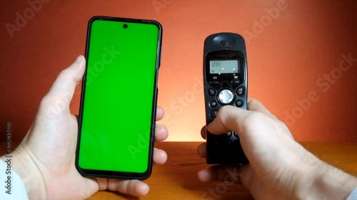 Closeup hand making a call composing numbers on keyboard telephone.