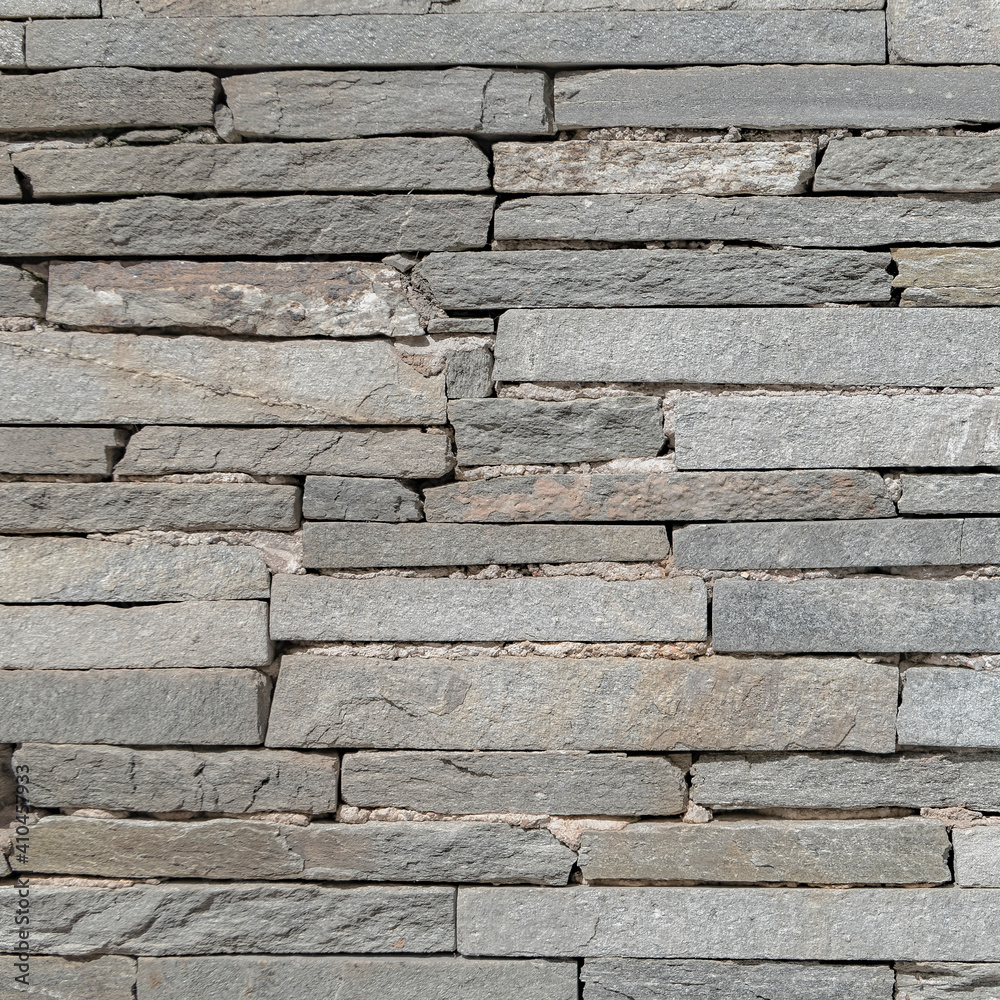 Obraz premium rough grey slate stone wall closeup, textured pattern background