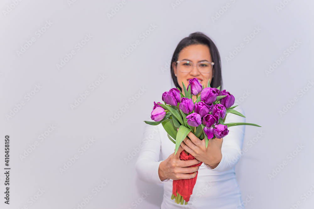 Mujer Latina sosteniendo un ramo de tulipanes.