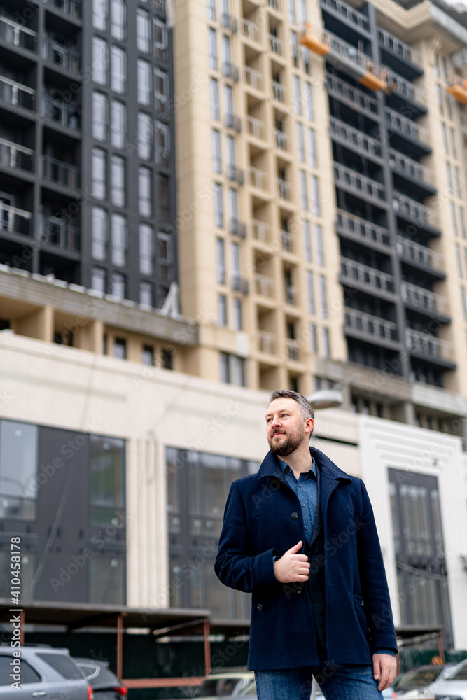 Portrait of a handsome young businessman standing outside a modern building. View from below. Portrait of a handsome young businessman standing outside a modern building. View from below.
