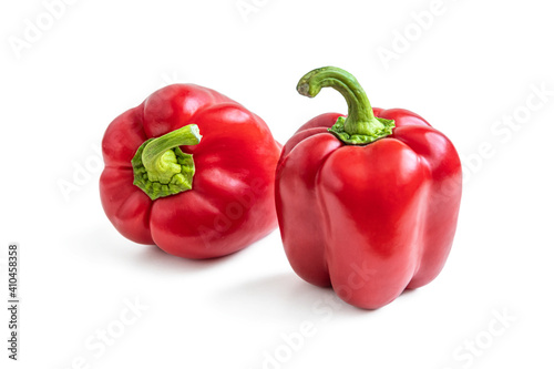 Two red shiny bell peppers on a white background