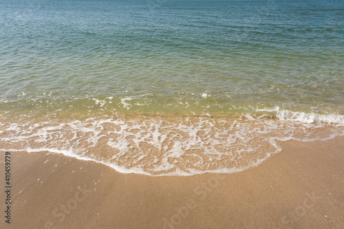 Soft ocean wave of blue ocean on tropical sandy beach in summer background with copy space. texture Background