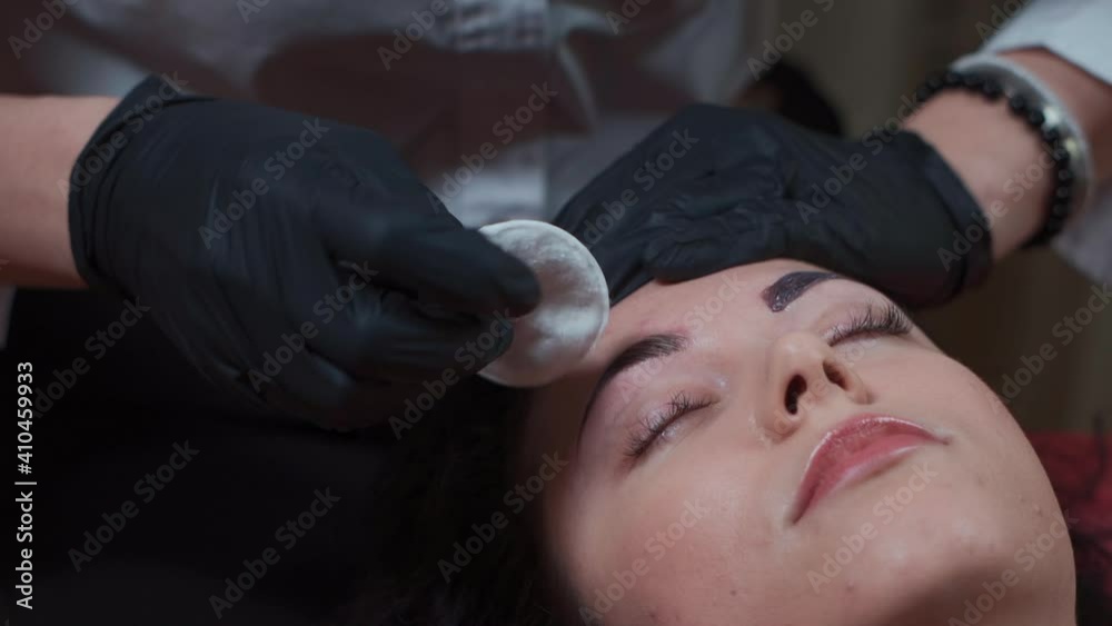 close up of beautician color female eyebrow and remove henna dye at beauty salon close up of beautician color female eyebrow and remove henna dye at beauty salon