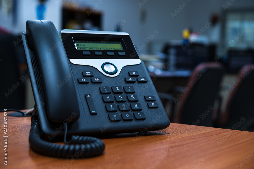 IP telephone device on wooden table in office room IP telephone device on wooden table in office room