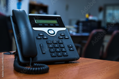 IP telephone device on wooden table in office room