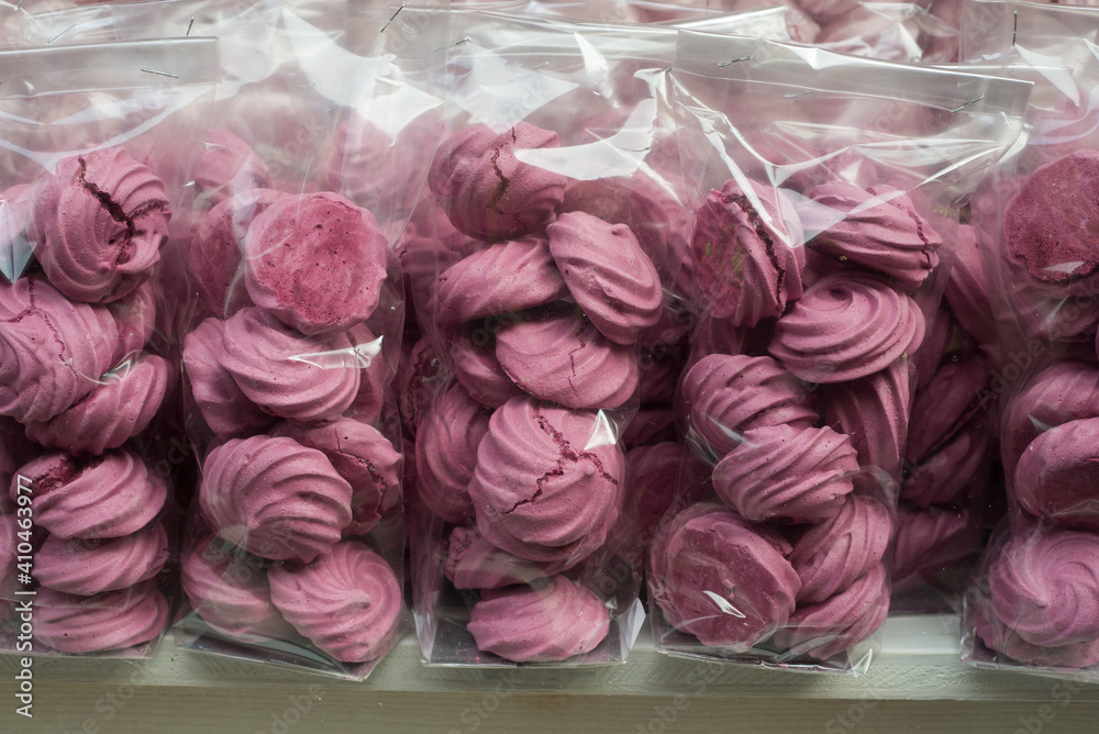 Closeup of pink meringues in plastics bags in a bakery store showroom Closeup of pink meringues in plastics bags in a bakery store showroom