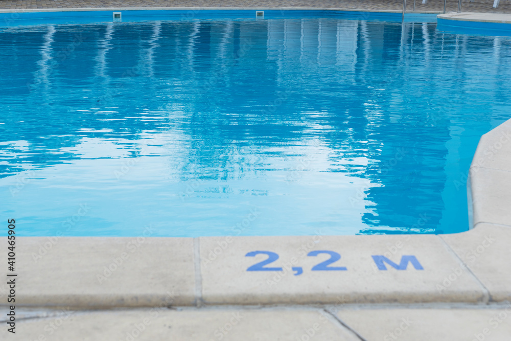 close up image of signs of depth in meters in swimming pool, deep pool with blue water, no people around,  safety on water