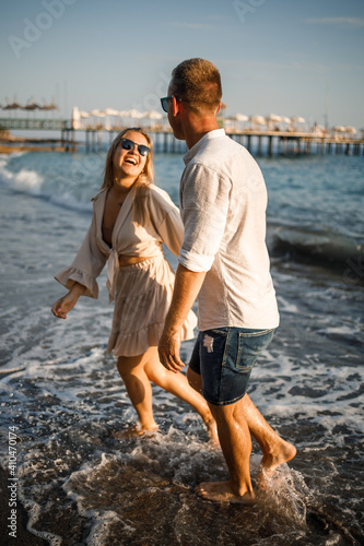 romantic young couple in love together on the sand walks along the beach of the Mediterranean sea. Summer vacation in a warm country. © Дмитрий Ткачук