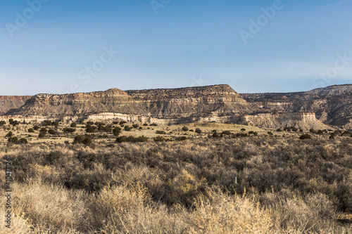 Open desert fields with brush and rocky mountains on clear day in rural New Mexico